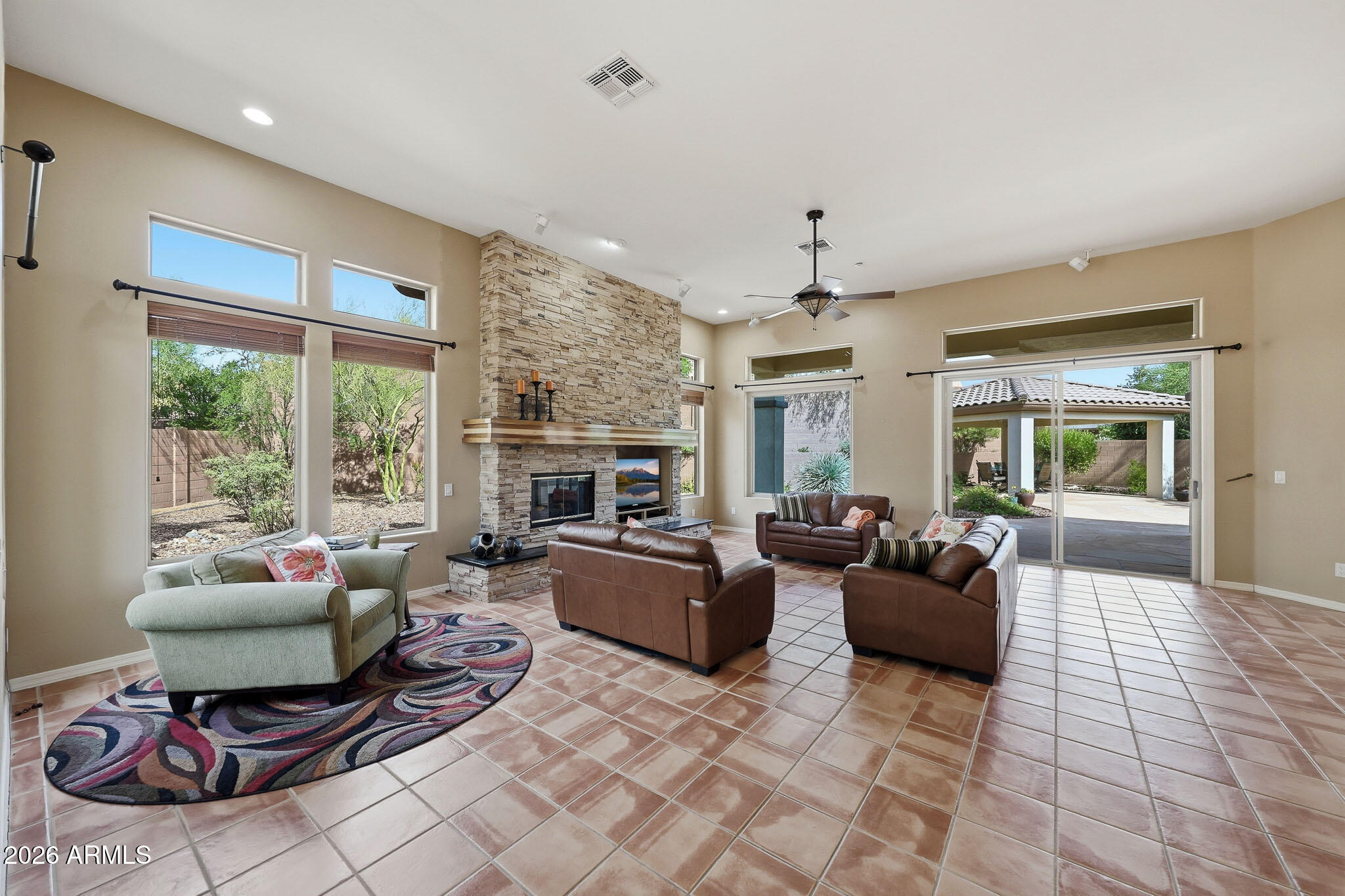 2129 West Legends Way Anthem, AZ 85086 - Photo 6 of 57 a living room with furniture a fireplace and a table