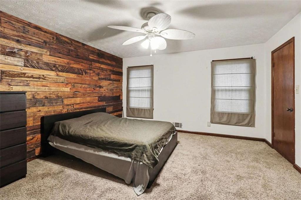 7495 Phillips Road Chattahoochee Hills, GA 30268 - Photo 10 of 26 a bed sitting in a room next to a window with a chandelier