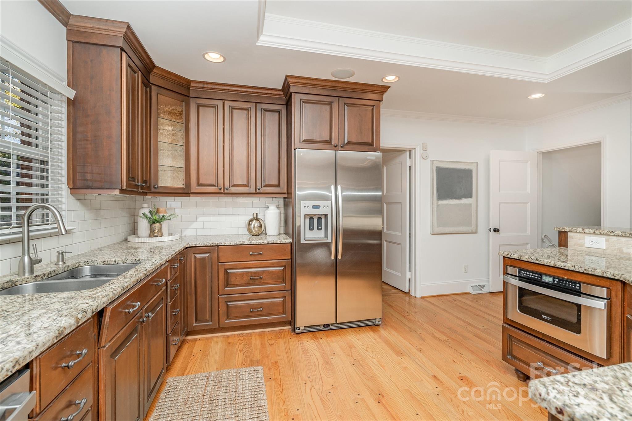 5411 Doncaster Drive Charlotte, NC 28211 - Photo 9 of 40 a kitchen with stainless steel appliances granite countertop a refrigerator a stove and a sink with wooden floors