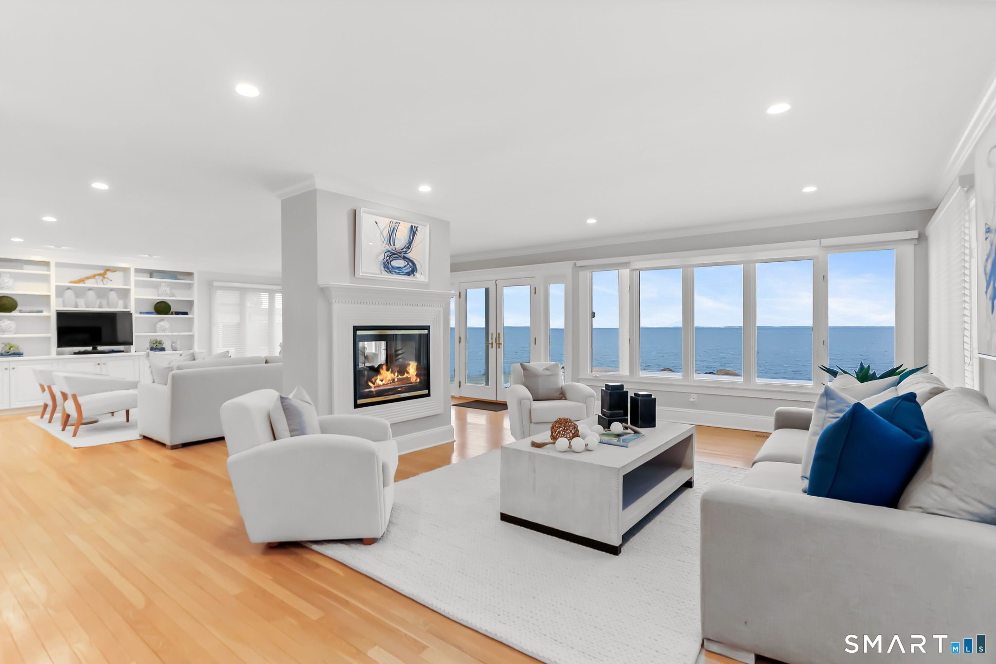 1149 Fairfield Beach Road Fairfield, CT 06824 - Photo 11 of 44 Formal living room w/with waterfront backdrop is balanced well adjacent family room joined nicely by the see through gas fireplace w/ convenient remote control