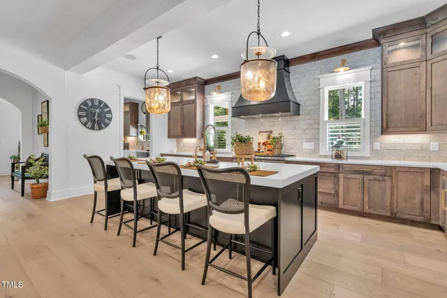 a kitchen with kitchen island stainless steel appliances a table chairs and a chandelier