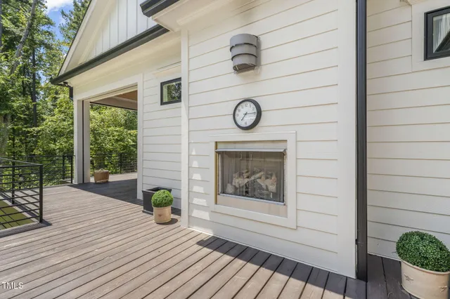 a view of a white house next to a yard with big trees