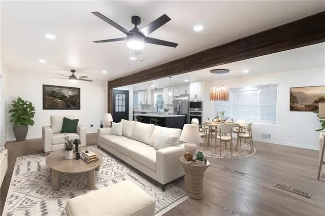 a living room with furniture kitchen view and a large window