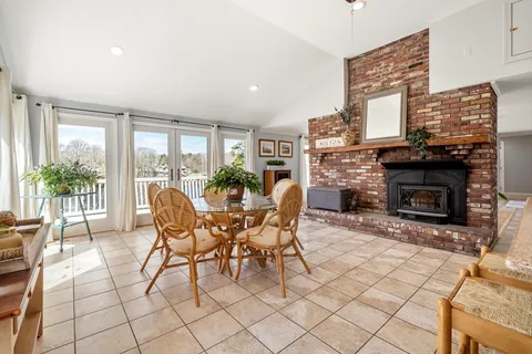 a dining room with furniture a fireplace and wooden floor