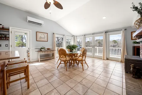 a dining room with furniture and large windows