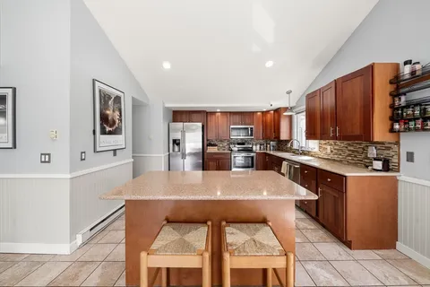 a kitchen with stainless steel appliances kitchen island granite countertop a refrigerator and microwave
