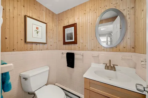 a bathroom with a toilet sink and mirror