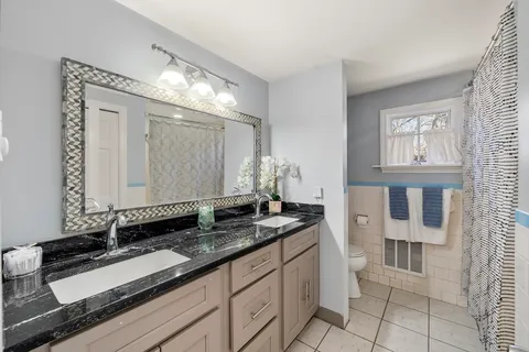 a bathroom with a granite countertop sink and a mirror
