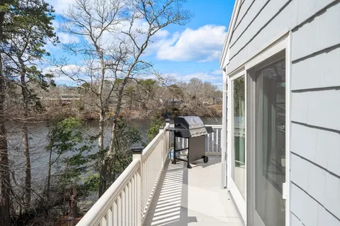 a balcony with wooden floor and outdoor seating
