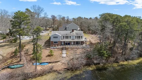 a view of a big house with a big yard and large trees