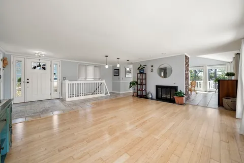 a view of a livingroom with furniture a fireplace and wooden floor