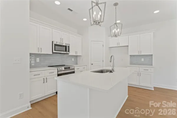 a kitchen with kitchen island granite countertop appliances cabinets and a counter top space
