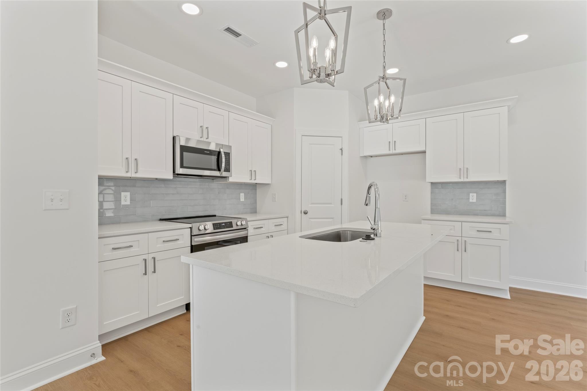 a kitchen with kitchen island granite countertop appliances cabinets and a counter top space