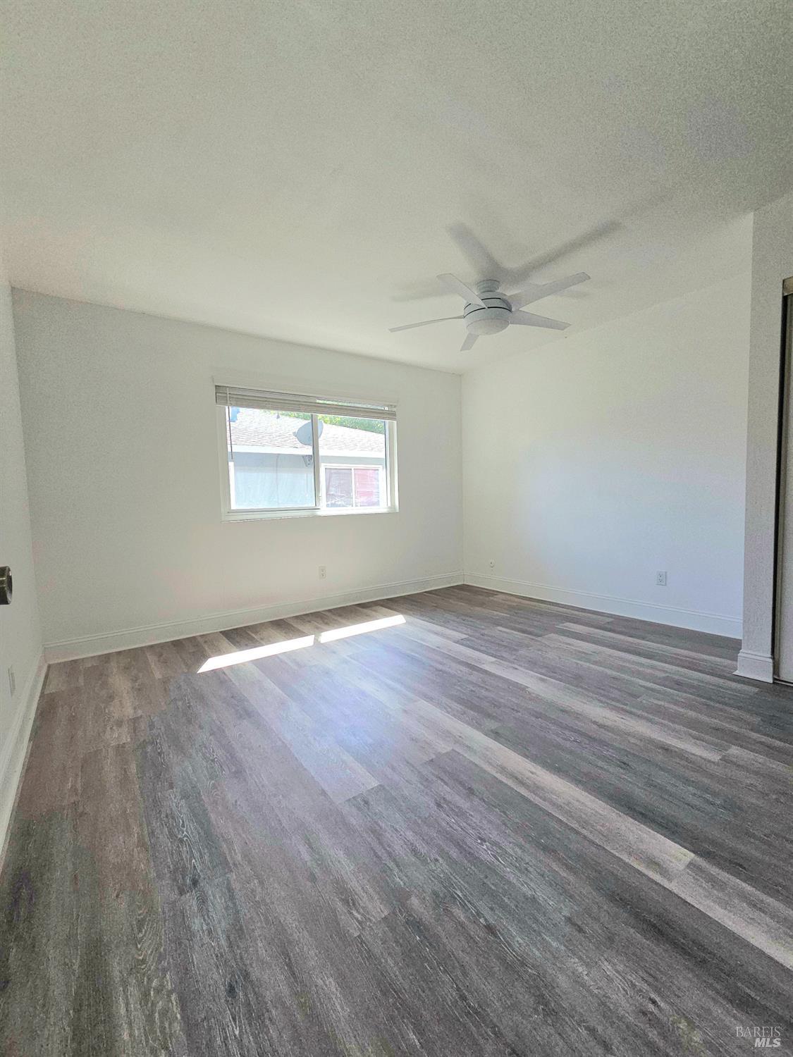 140 Del Rio Court, Unit 4 Vacaville, CA 95687 - Photo 15 of 25 an empty room with wooden floor and windows