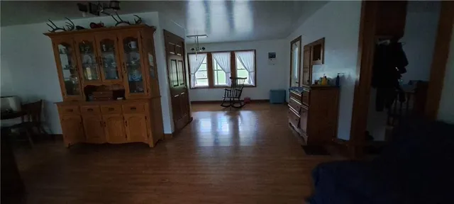 a view of a hallway with wooden floor windows and a livingroom