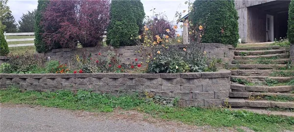 a view of a house with a yard and flower garden