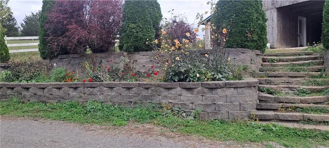 a view of a house with a yard and flower garden