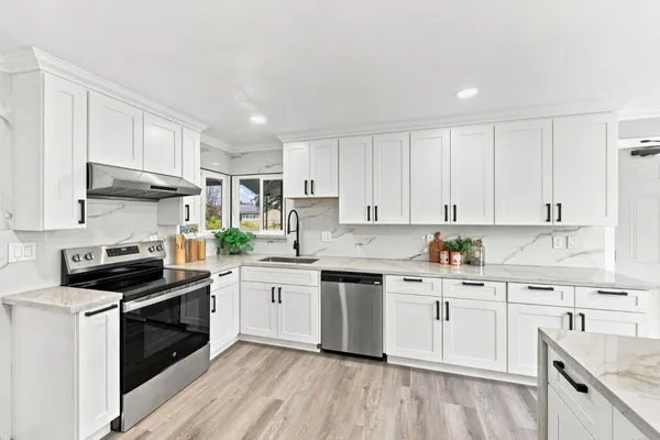 a kitchen with a white stove top oven sink and cabinets