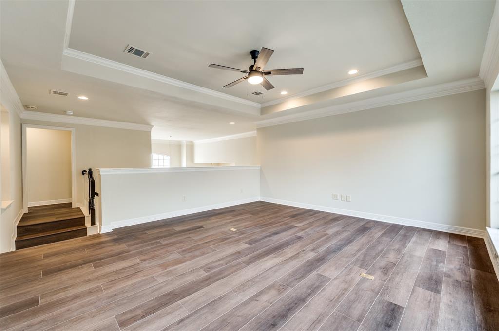 4015 Stonehollow Way Dallas, TX 75287 - Photo 18 of 26 a view of an empty room with wooden floor and a ceiling fan