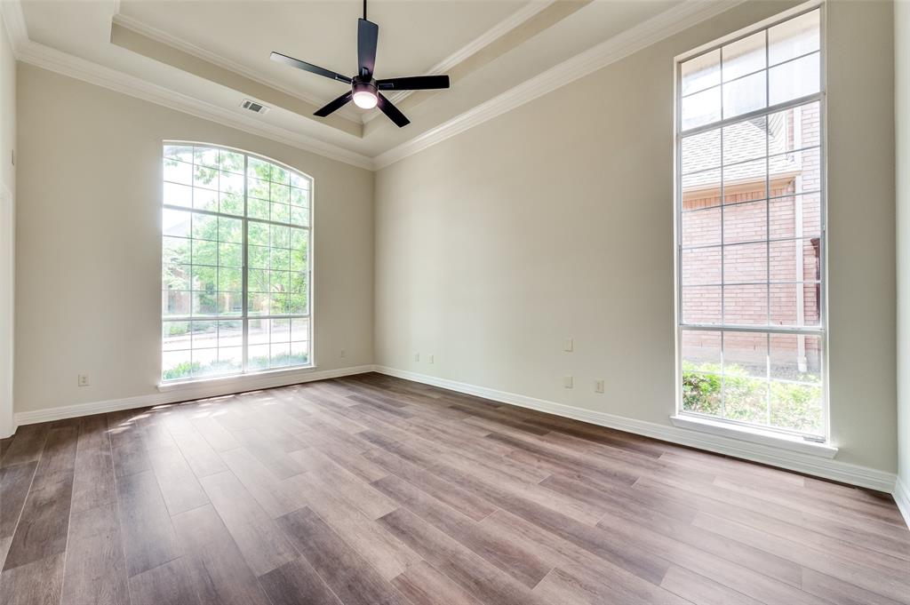 4015 Stonehollow Way Dallas, TX 75287 - Photo 20 of 26 an empty room with wooden floor fan and windows