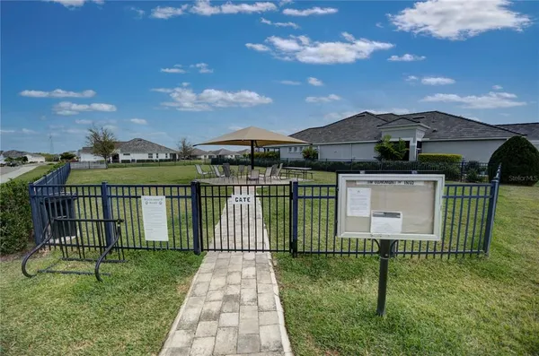 a front view of multi story residential apartment building with yard and sign board