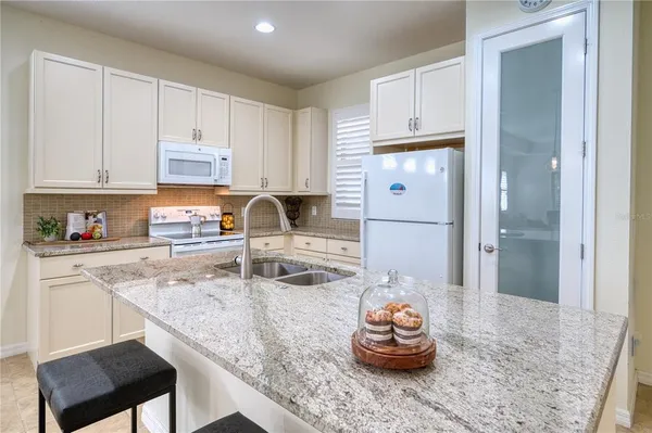 a kitchen with granite countertop a sink stove and cabinets