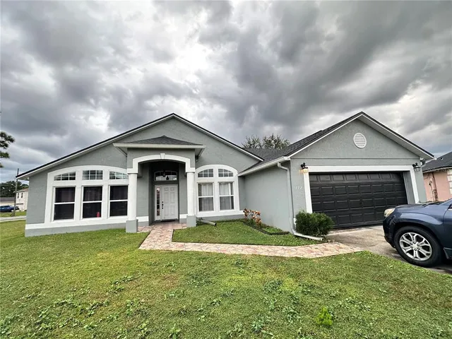 a view of a house with a yard and garage