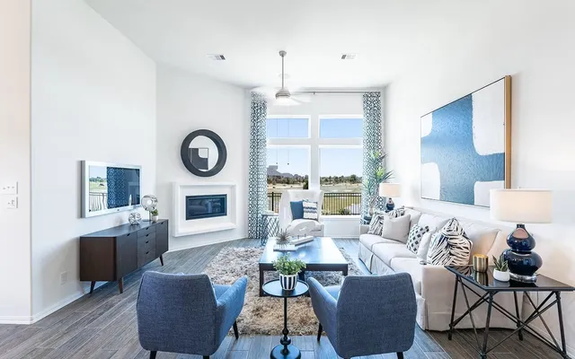 a living room with furniture a fireplace a rug and a window