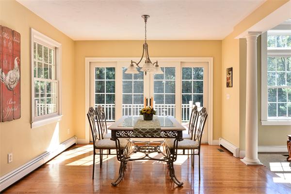108 Deerfield Lane Hanover, MA 02339 - Photo 7 of 28 a dining room with wooden floor a chandelier a glass table and chairs