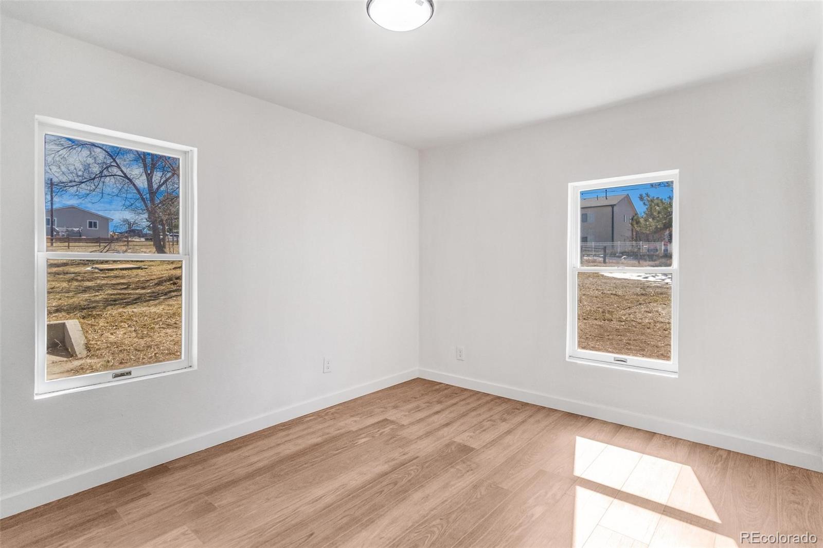 350 South Elbert Street Elizabeth, CO 80107 - Photo 13 of 22 a view of an empty room with wooden floor and a window