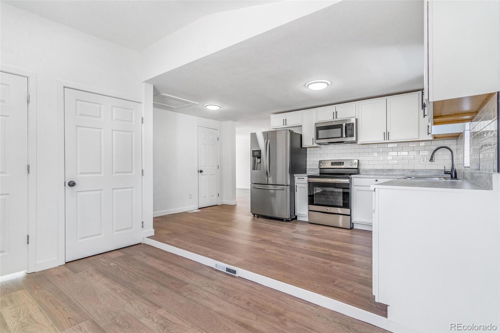 350 South Elbert Street Elizabeth, CO 80107 - Photo 14 of 22 a kitchen with wooden floor and stainless steel appliances
