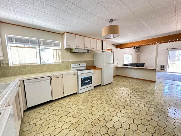 a kitchen with cabinets and wooden floor