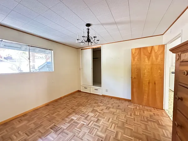 a view of a big room with wooden floor and windows
