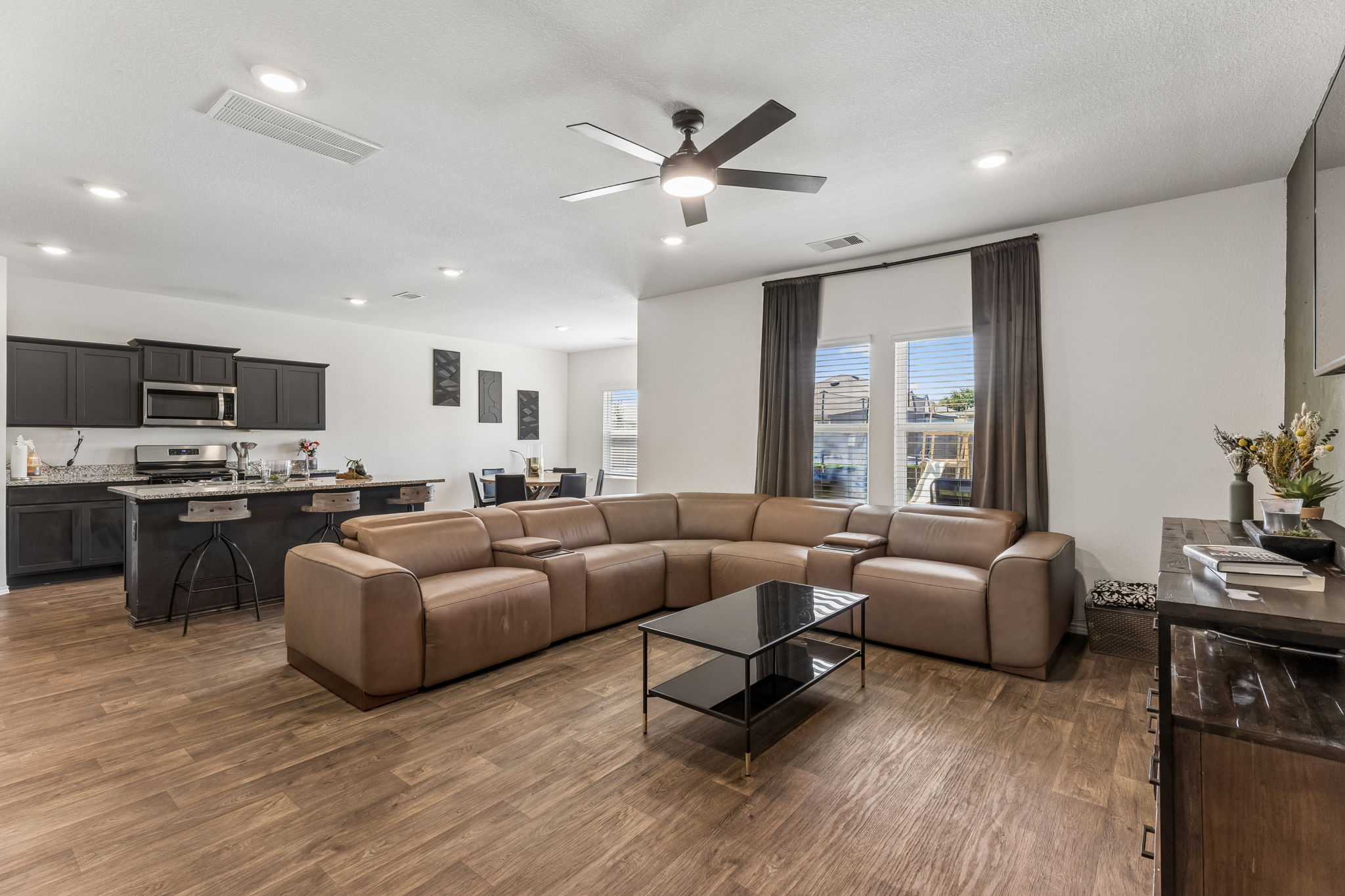 343 Sickle Loop Kyle, TX 78640 - Photo 10 of 40 Open-concept living area featuring wood-finish flooring, recessed lighting, and a ceiling fan