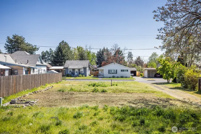 a view of a house with a big yard and large trees