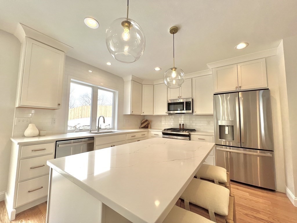 20 Sandy Pond Road, Unit 20 Ayer, MA 01432 - Photo 6 of 25 a open kitchen with stainless steel appliances granite countertop a sink refrigerator and microwave