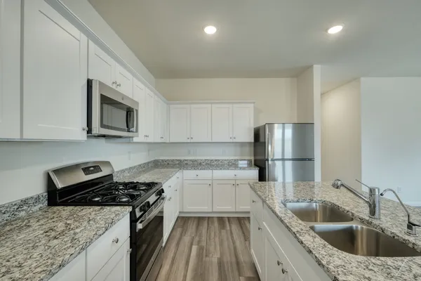 a kitchen with a sink stove top oven and refrigerator