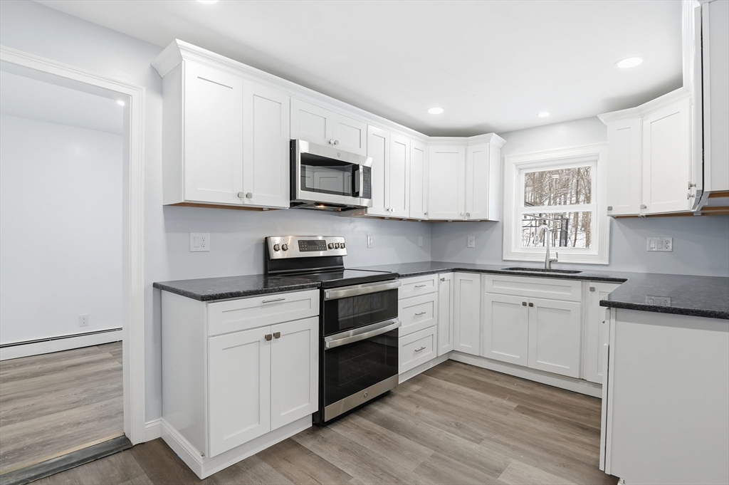 104 Temple Street Gardner, MA 01440 - Photo 11 of 40 a kitchen with stainless steel appliances granite countertop a stove a sink and a microwave