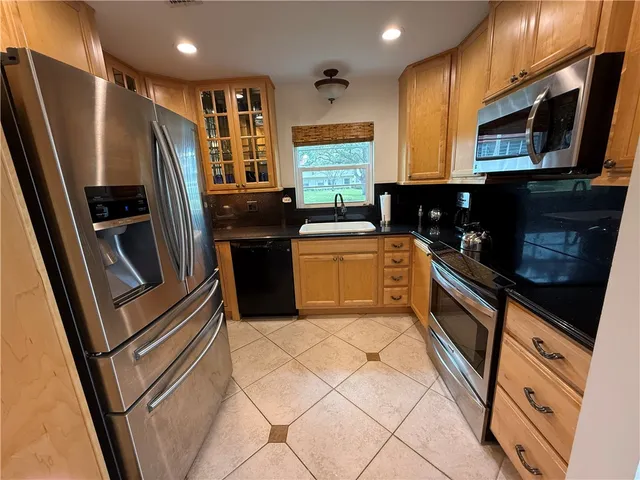 a kitchen with stainless steel appliances granite countertop a refrigerator stove and sink