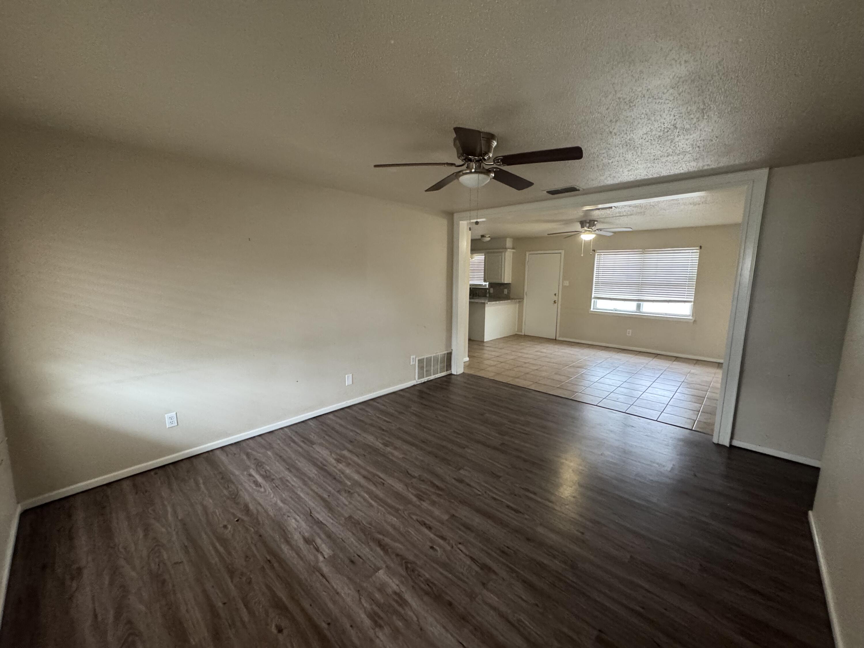 601 Chicago Avenue Lubbock, TX 79416 - Photo 2 of 12 an empty room with wooden floor and windows