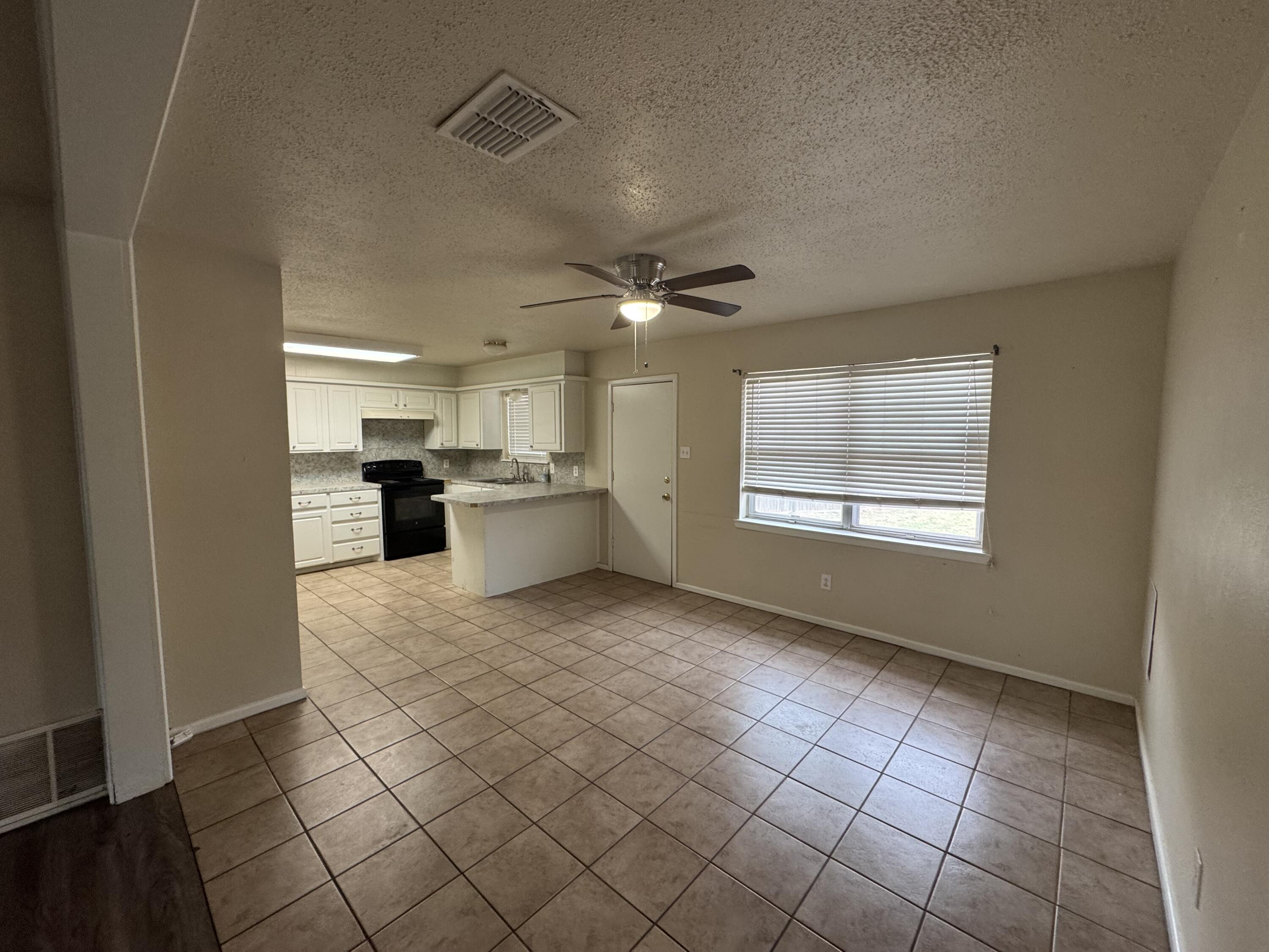 601 Chicago Avenue Lubbock, TX 79416 - Photo 3 of 12 a view of an empty room with a kitchen