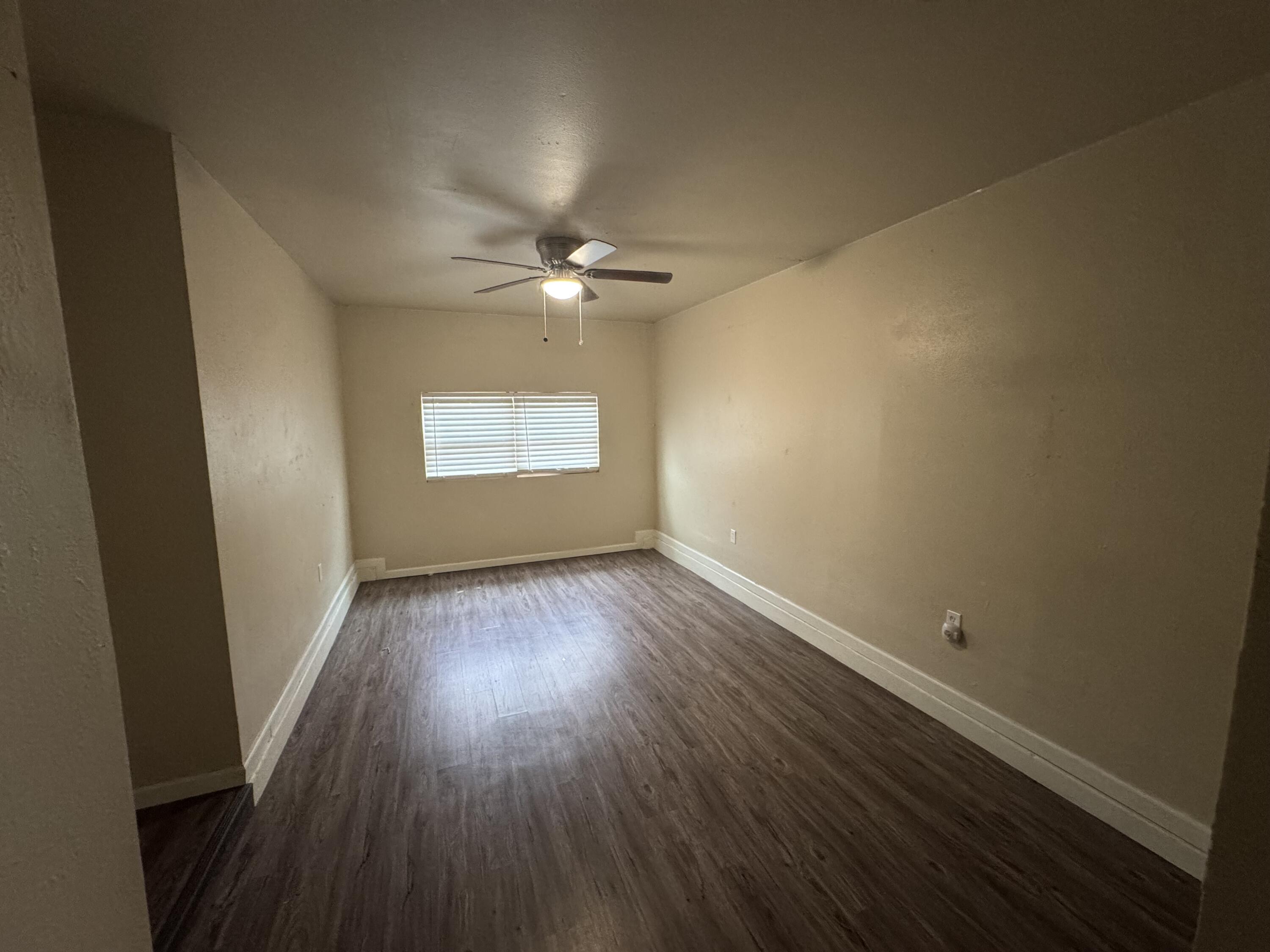 601 Chicago Avenue Lubbock, TX 79416 - Photo 5 of 12 an empty room with wooden floor and windows