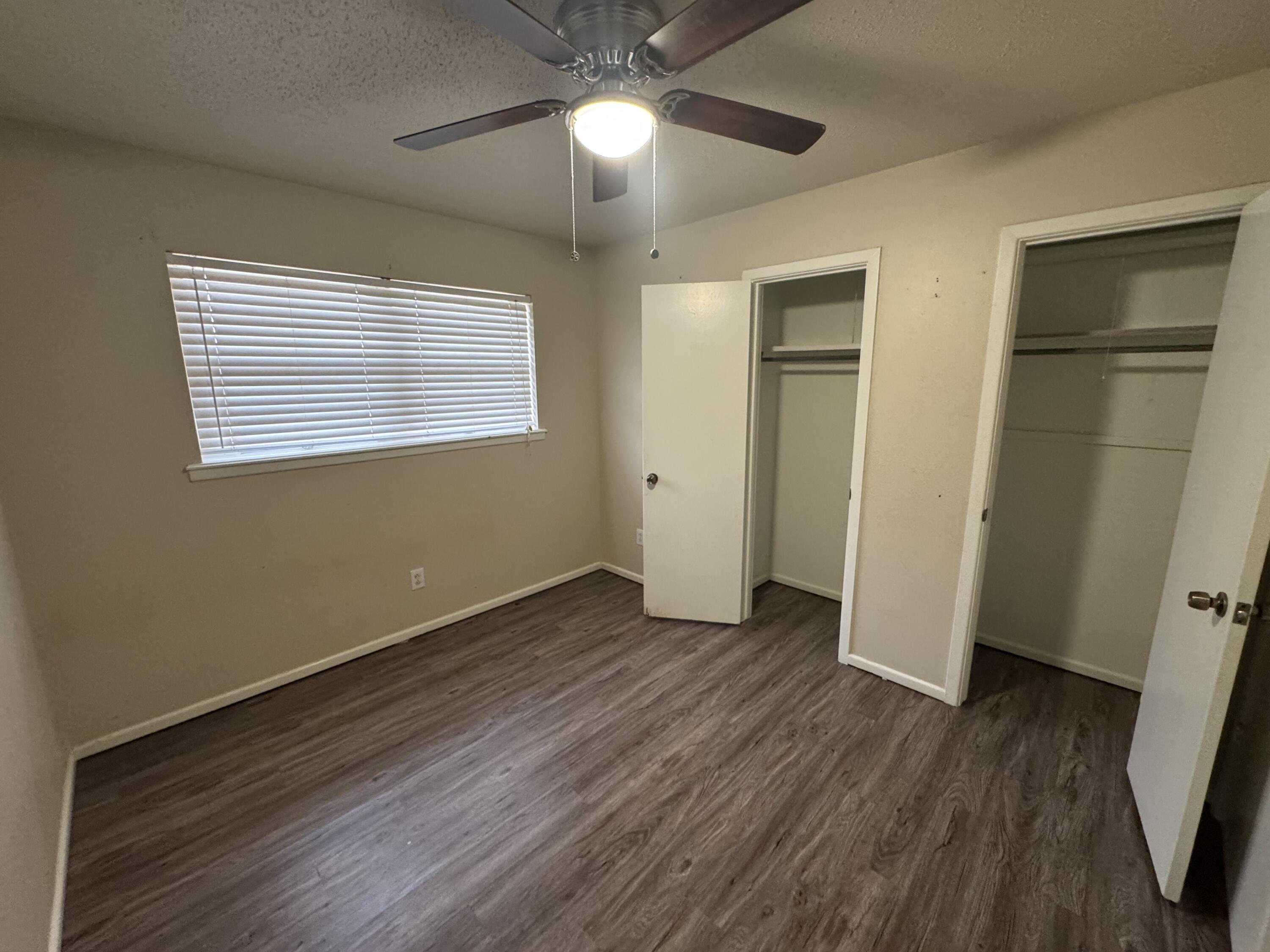 601 Chicago Avenue Lubbock, TX 79416 - Photo 7 of 12 a view of an empty room with wooden floor and a window