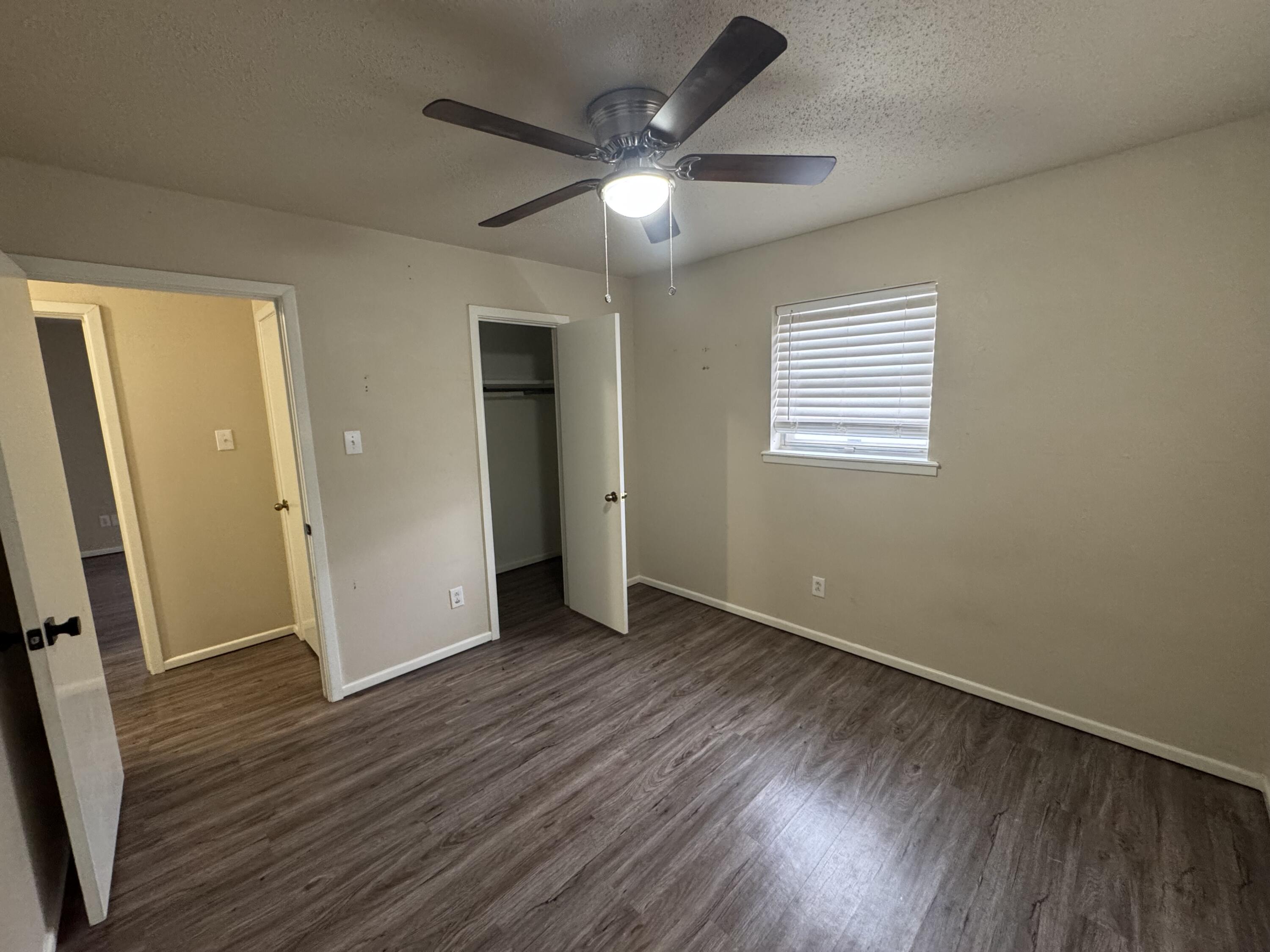 601 Chicago Avenue Lubbock, TX 79416 - Photo 9 of 12 a view of an empty room with wooden floor and a window