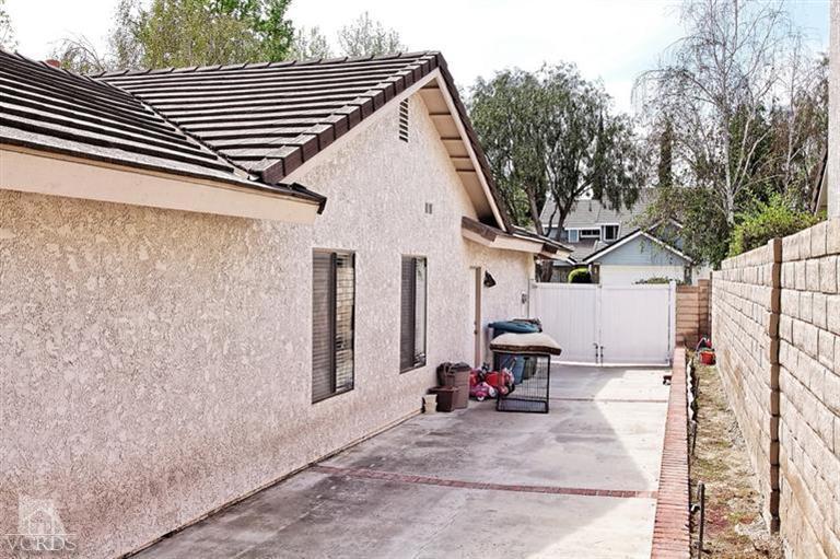 2704 Bitternut Circle Simi Valley, CA 93065 - Photo 23 of 25 a view of a patio with table and chairs with wooden fence and large trees