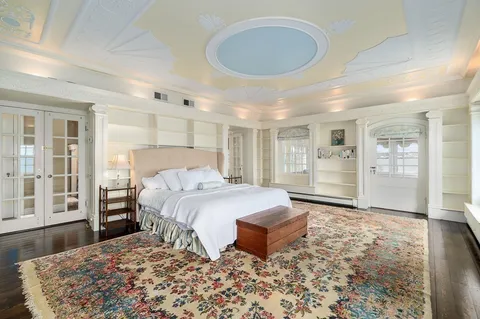 a spacious bedroom with a large bed and a chandelier