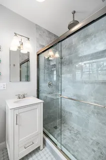 a bathroom with a shower sink and mirror