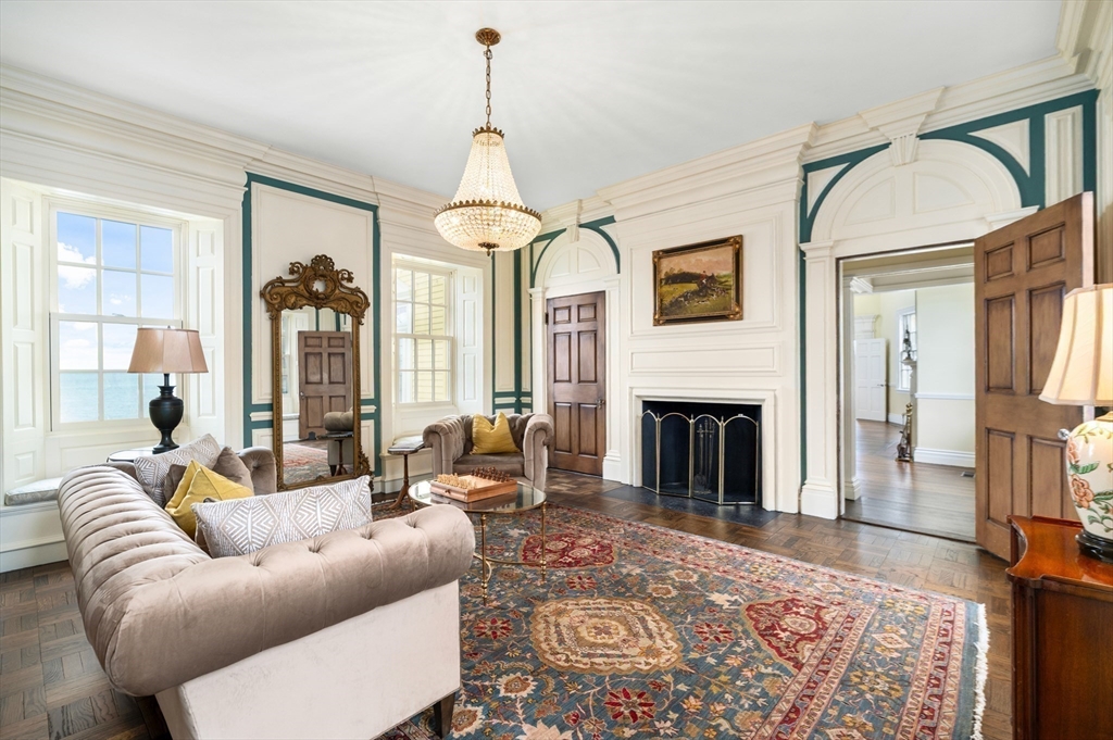 66 Ocean Street Nahant, MA 01908 - Photo 6 of 40 a living room with furniture a fireplace and a chandelier