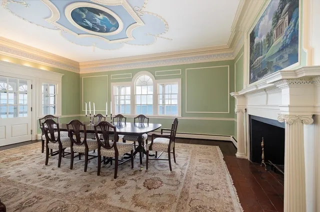a dining room with furniture a floor to ceiling window and a fireplace