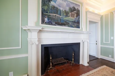 a living room with a fireplace and a painting on the wall